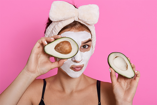 Beautiful spa woman with Avocado facial mask 